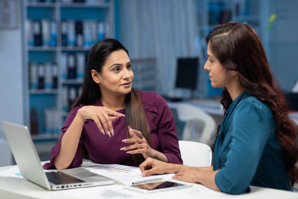 istock female employees discuss work issues sitting at office, explain ideas at workplace table stock photo 1302683848