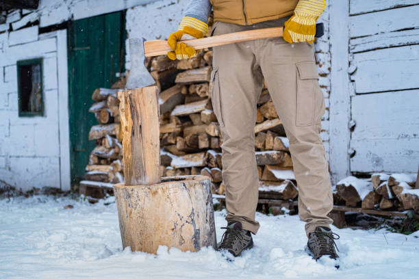A man chops a piece of firewood. In the same moment as the wood splits the photograph is taken with a backlit flash. Freezing all the small particles that explodes.