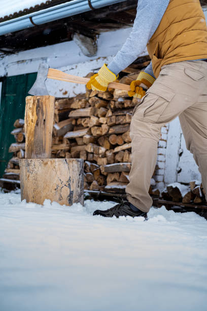 istock Man with an axe cutting wood on a tree stump. 1302684696