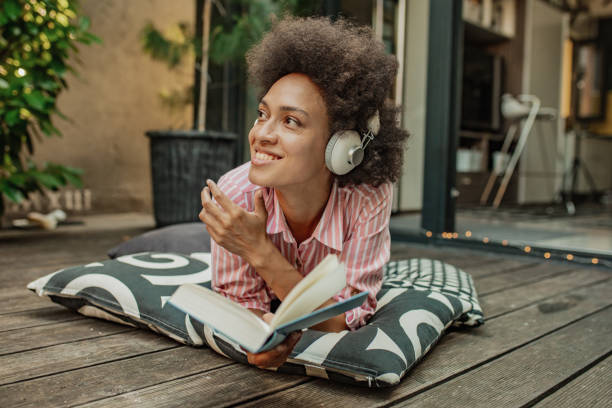 istock Beautiful woman enjoying while reading a book at home 1302685895