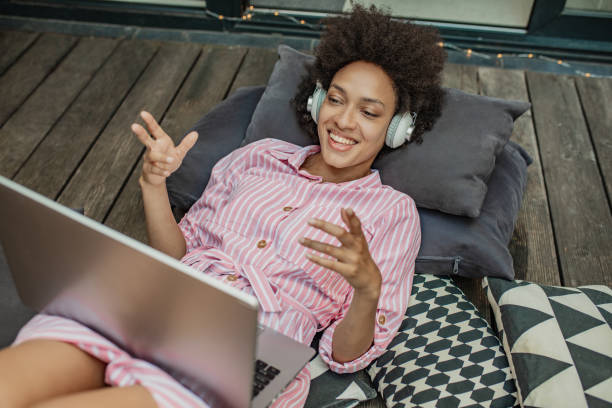 istock Woman is using laptop and communicating on a video call at home on the balconz 1302685946