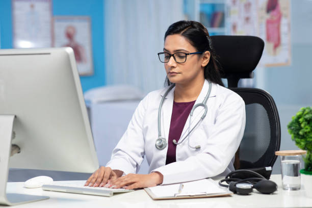istock Female Doctor using desktop pc  stock photo 1302688299