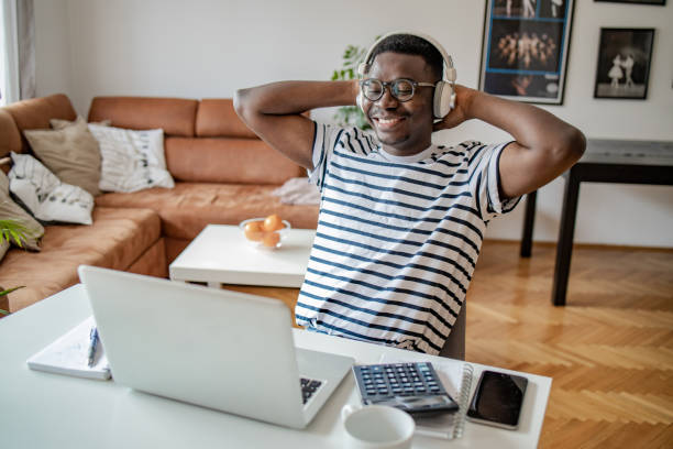 istock Happy young African American man at home, using laptop 1302689212