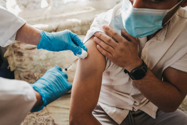 istock Young man gets a COVID-19 vaccine at his home 1302694273