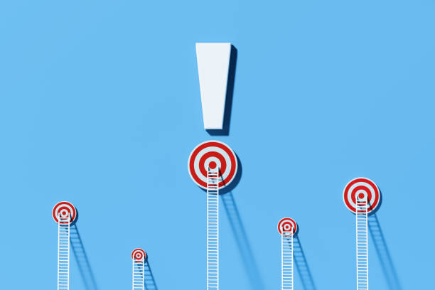 istock Warning Concept - White Ladders Leaning On To Bull's Eye Targets Which Sit Below An Exclamation Point Written Blue Wall 1302695401