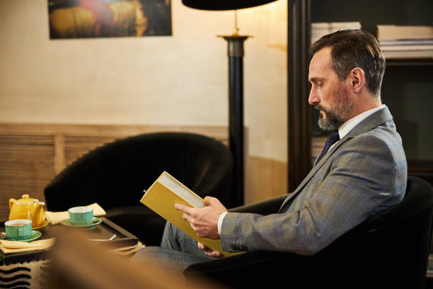 istock Focused elegant man reading a breathtaking book 1302695598