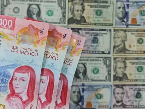 approach to mexican banknotes and background with American dollars bills of different denomination