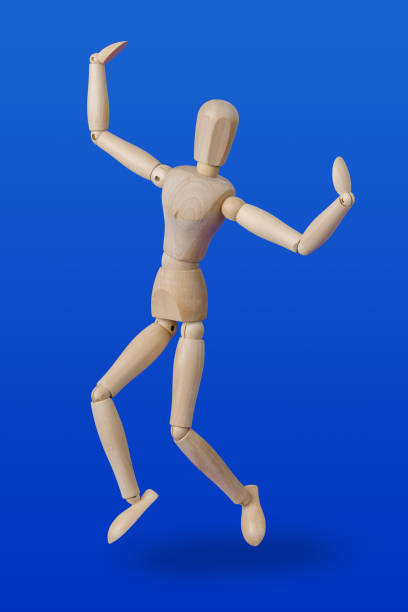 istock Dancing wooden toy figure on blue 1302700367