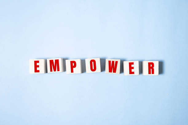 Empower word written on wood block on blue . Empower word written on wood block on blue employee encouragement stock pictures, royalty-free photos & images