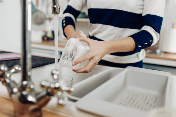 Unrecognizable girl washing plastic dishes