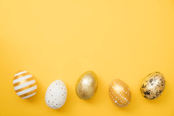 istock Easter golden decorated eggs on yellow background. Minimal easter concept. Happy Easter card with copy space for text. Top view, flatlay 1302703120