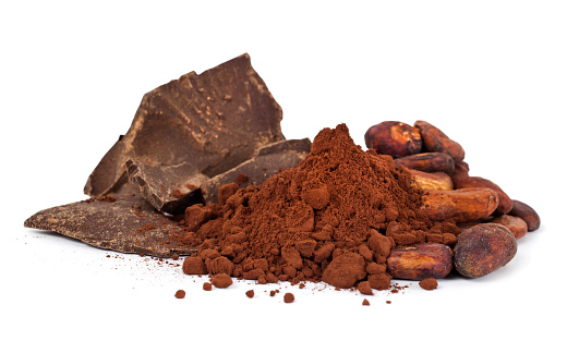 Cocoa beans with cocoa powder and chocolate pieces isolated on a white background.