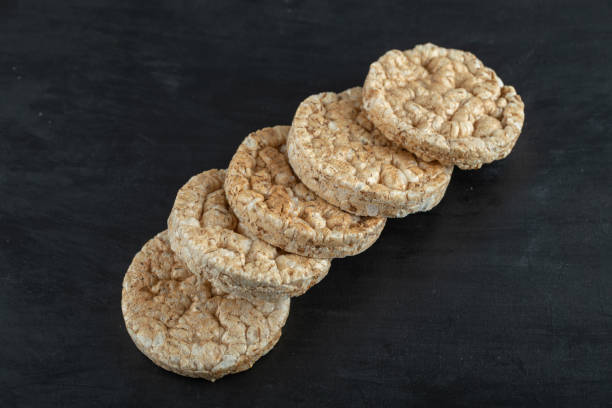 istock Pile of crispy rice cakes on black background 1302704008