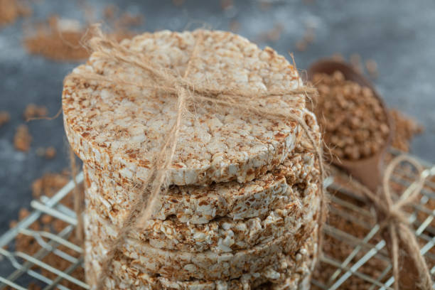 istock Stack of rice cakes and scattered buckwheat on marble surface 1302706273