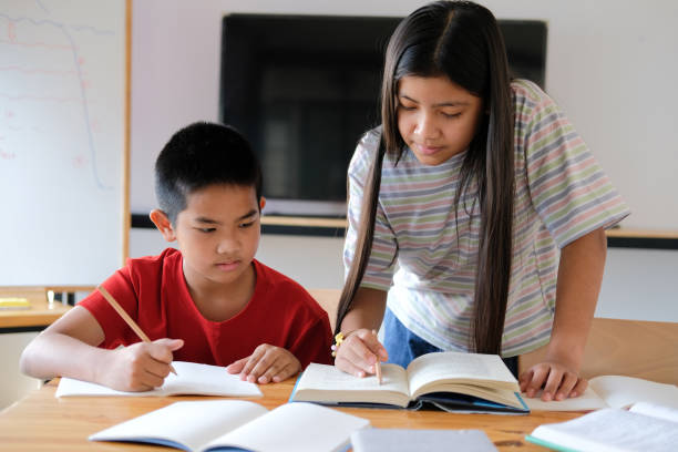 istock boy girl student studying writing notes doing homework. learning education at school 1302708293