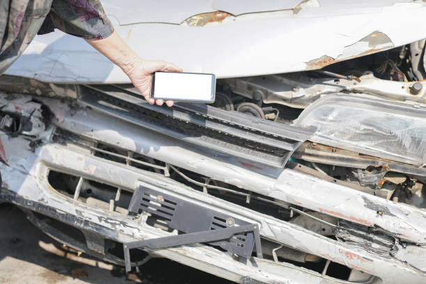 istock hand take photo of crashed damaged broken car. automobile crash accident 1302708370