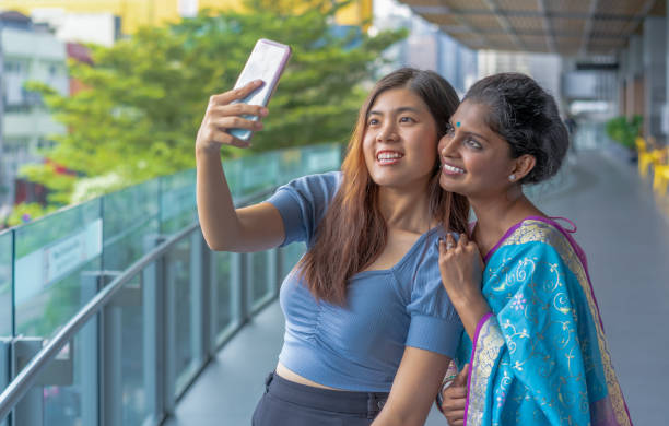 istock Malaysia Two Ethnicity Selfie Together Outdoor 1302714310