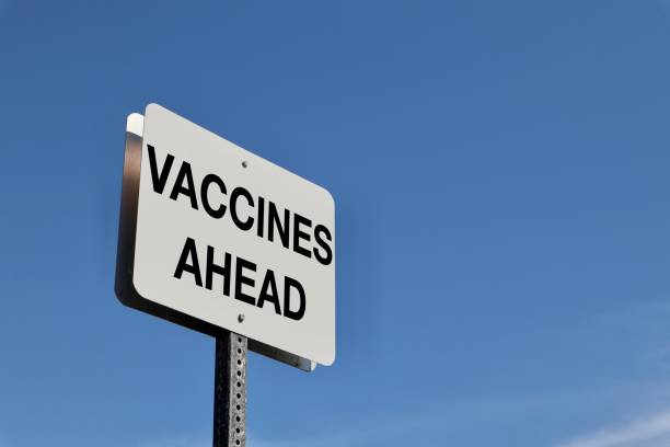 istock Vaccines Ahead sign against blue sky 1302714602