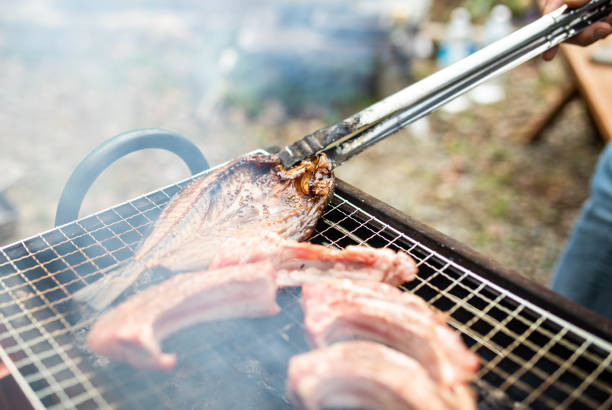 istock Close up meat and fish on a BBQ grill 1302715278