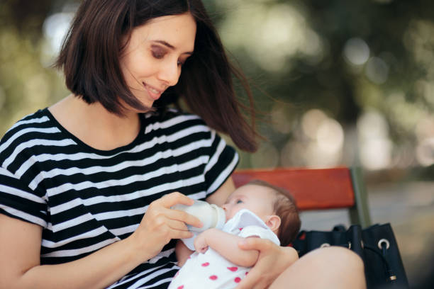 istock Mother Bottle Feeding Baby Outdoors in the Park 1302716211