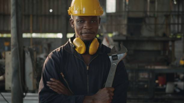 istock Engineer standing holding wrench tools and arms crossed at work in the industry 1302723836