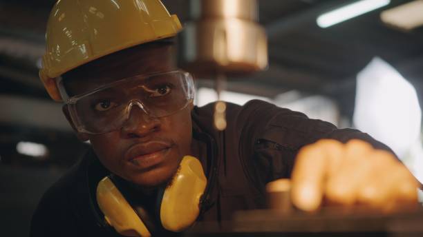 istock worker man with yellow helmet and ear protection manual rotating on drill machine 1302723848