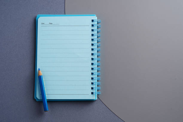 blaue farbe notizblock auf grauem hintergrund - workbook note pad cut out pencil stock-fotos und bilder