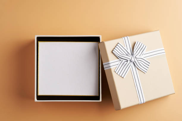 istock open present box with blank card for copy space on orange background 1302725464