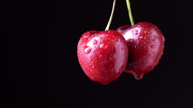 4k : Water splashes on a bunch of red cherries