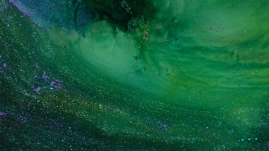 Green color strands oil paint pouring close up. Luxury Fluid Art painting. Inkscape movement macro. Abstract art background