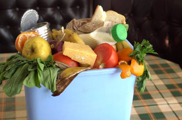 食べられない甘やかされた野菜がゴミ箱に捨てられる。食品の損失と食品廃棄物。家庭での無駄な食べ物の削減 - 喪失 写真 ストックフォトと画像
