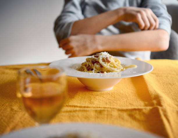 pasta carbonara garnished with bacon and parmesan cheese.