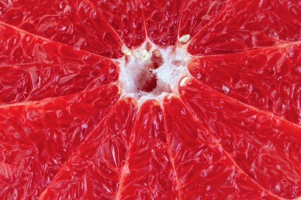 istock Juicy appetizing pulp of red grapefruit is extremely close view. 1302734021