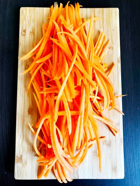 istock ready-to-cook grated carrots on a wooden table. 1302734938
