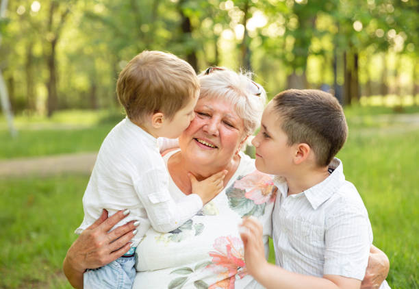 istock Granny with grandsons enjoying time together in summer park. 1302736329