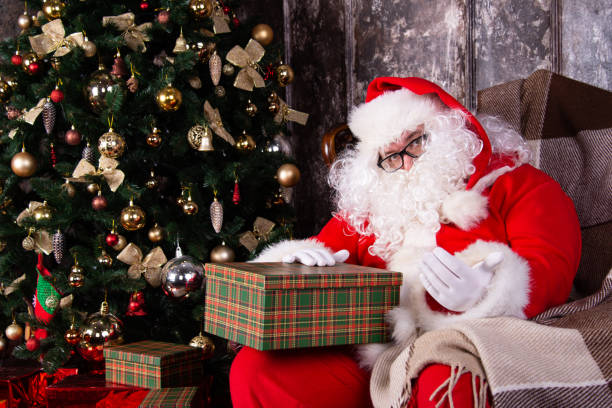 istock Christmas presents. Santa Claus by the Christmas tree. 1302736666