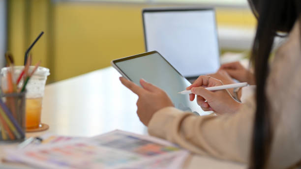istock Female office worker hand working mock up digital tablet with stylus pen in office room 1302737631
