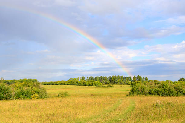 istock green field and part of a rainbow above it 1302738320