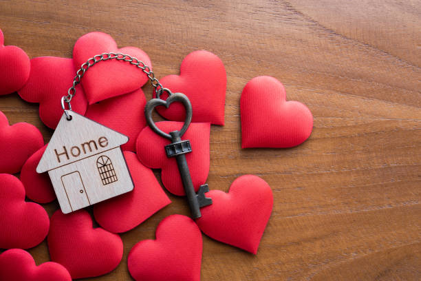 istock House key with home keyring decorated with mini heart on rusty wood background, copy space 1302741584