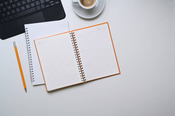 istock Above view of empty notebook, pencil, coffee cup and copy space on white background. 1302741620