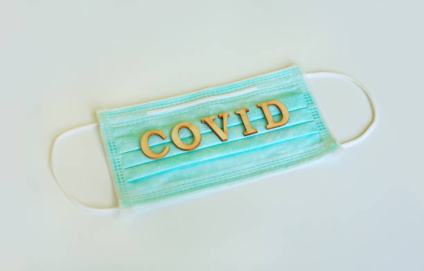 istock Medical shielding mask with word COVID isolated over white background. 1302741861