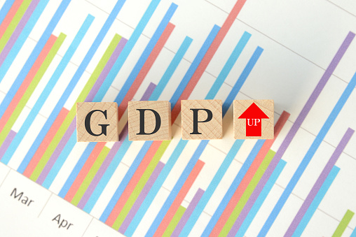 Wooden blocks with GDP words and upward arrow sign on business chart