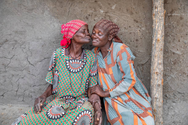 istock two friendly elderly woman sitting next to the house wall 1302743687