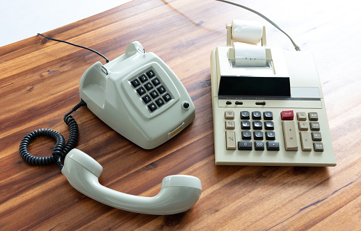 Old fashioned calculator and telephone on desk