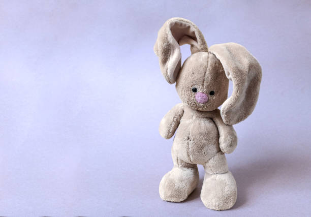 istock The soft toy bunny stays on a bright violet background 1302746193