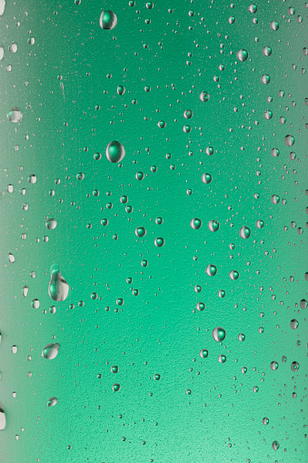 Condensation on glass bottle. Ice Cold Drinking glass With Water Drops  Green backgrounds