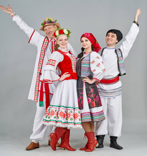 Two Pairs Of Dancers In Belarus And Moldova Folk Clothes Are Standing And Looking Cheerfully At Camera A group of dancers different age are dressed in paired (female and male) Belarus and Moldova traditional clothes. They are posing together, smiling looking at the camera. Studio shooting russian ethnicity stock pictures, royalty-free photos & images