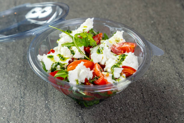 istock Tomato and mozzarella salad with arugula in disposable container 1302749214