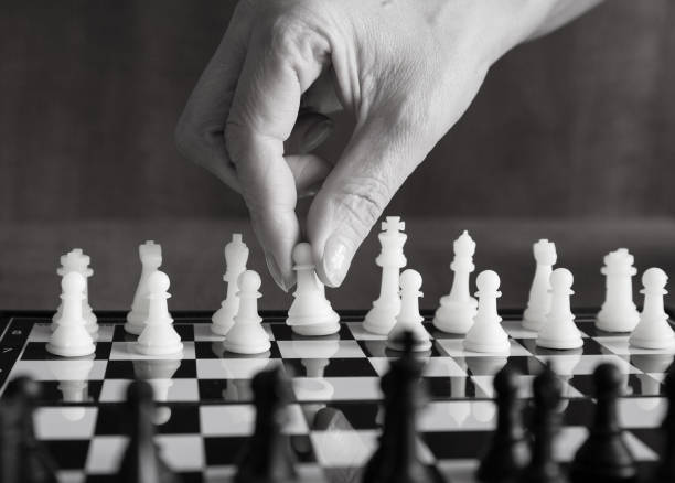 istock Chess game, the player moves a pawn. Black and white image. Tactics and strategy. 1302751127