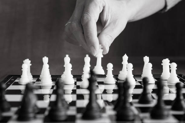 istock Chess move, movement of a chess piece female hand. Black and white image. 1302751164